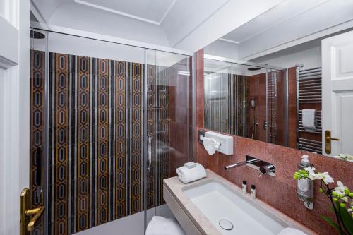 a bathroom with a tub and a large mirror at Albergo California in Positano