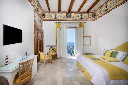 a hotel room with a bed and a table and a desk at Albergo California in Positano