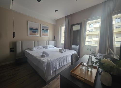 a bedroom with a white bed and a table at Uma Premium in Ulcinj