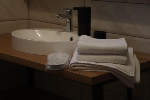 a bathroom sink with towels on a wooden counter at Palas rooms in Smederevska Palanka