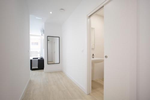 a hallway with white walls and a mirror at Urbil Puente Colgante in Portugalete