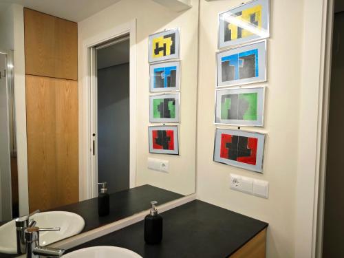 a bathroom with two sinks and paintings on the wall at Vivienda Bendicho- CATEDRAL in Almería