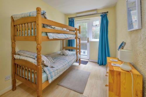 a bedroom with two bunk beds and a desk at Finest Retreats - Delfryn in Talysarn