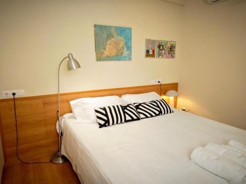 a bedroom with a bed with two pillows on it at Vivienda Bendicho- CATEDRAL in Almería