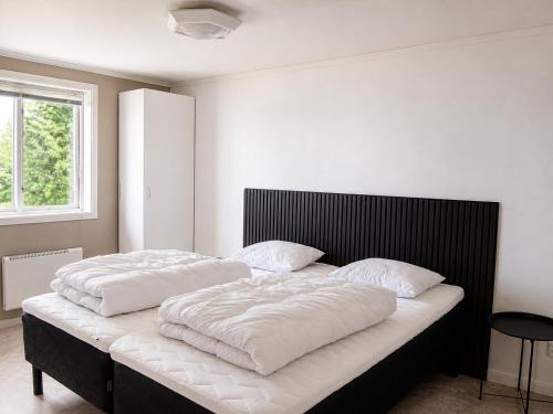 a bedroom with two beds with white sheets at Solbacka apartments Norr - Panorama view in Södra Ås