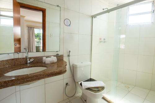 a bathroom with a toilet and a sink and a shower at Rede Andrade Barravento in Ilhéus