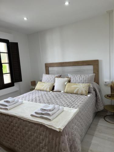 a bedroom with a large bed with towels on it at El Encanto de Sixto in Santa Marta de Ortigueira