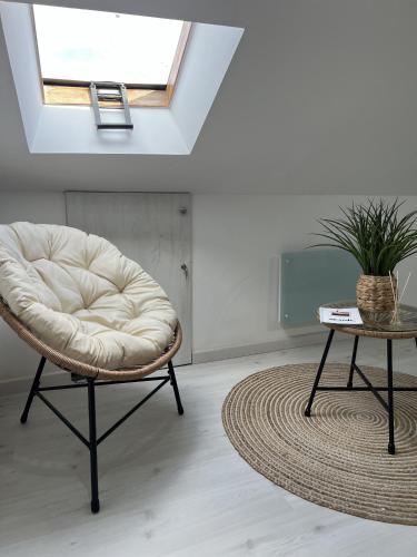 a white chair and a table in a room at El Encanto de Sixto in Santa Marta de Ortigueira