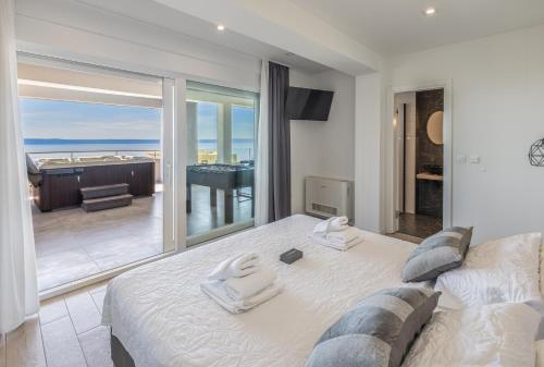 a bedroom with a bed and a view of the ocean at Villa Collis in Makarska