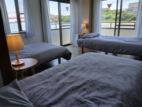 a hotel room with two beds and a window at ゲストハウスMoana 那珂湊おさかな市場徒歩5分,9名可,BBQ可 in Hitachinaka
