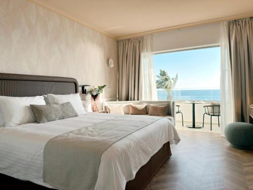 a bedroom with a bed with a view of the ocean at Imperial Island by Louis Hotels in Yeroskipou