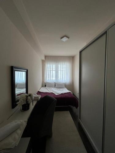 a small bedroom with a bed and a mirror at Central apartment 4 in Gnjilane