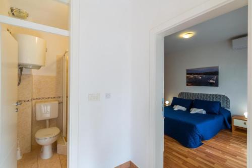 a bedroom with a blue bed and a toilet at Sun Palace Residence in Premantura