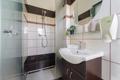 a bathroom with a sink and a shower at KisEtyek Vendégház in Etyek
