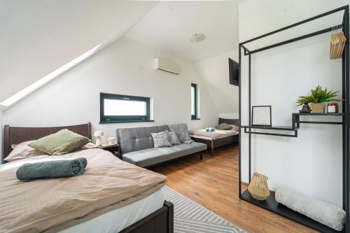 a bedroom with a bed and a living room at KisEtyek Vendégház in Etyek