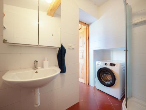 a bathroom with a sink and a washing machine at Chalupa Domovina in Jiřetín pod Jedlovou