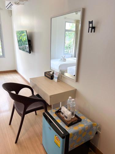 a room with a mirror and a table and a chair at Taradii Boutique in Bangkok