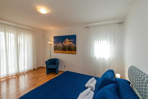 a bedroom with a blue bed and a blue chair at Sun Palace Residence in Premantura