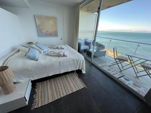 a bedroom with a bed and a balcony with the ocean at C'est la vie! in L'Escala