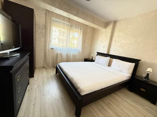 a bedroom with a bed and a flat screen tv at Holidays Summer Vibes Apart Mamaia Nord in Năvodari