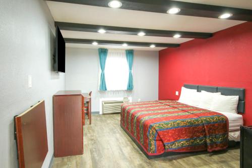a hotel room with a bed and a red wall at Marshall Lodge By OYO Hwy 65 in Marshall