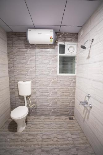 a bathroom with a white toilet and a shower at Z Express Anoop in Bangalore