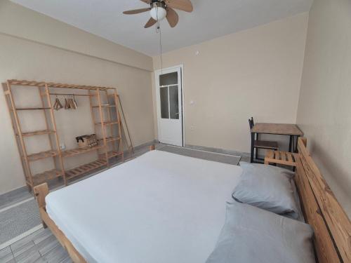 a bedroom with a large bed and a fan at Teraslı Müstakil Ev in Cunda