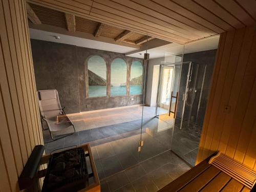 a bathroom with a glass shower in a room at epOche Hotel 1889 in Nago-Torbole