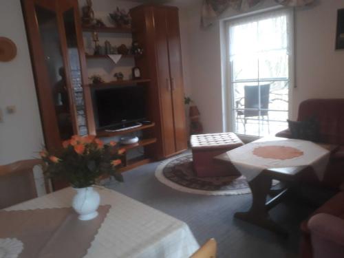 a living room with a vase of flowers on a table at Ferienwohnung Ewen 55038 in Filsum