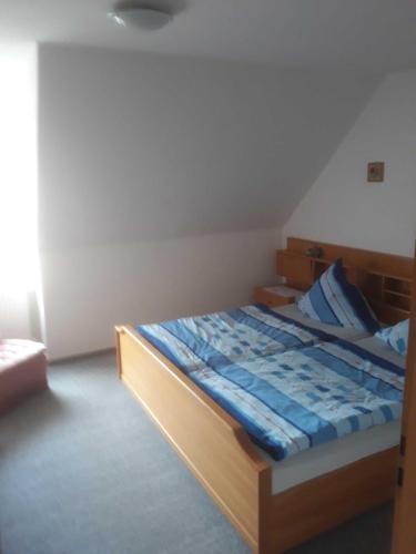 a bedroom with a wooden bed with blue sheets at Ferienwohnung Ewen 55038 in Filsum