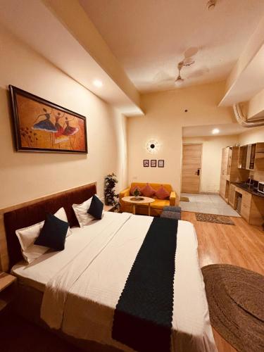 a bedroom with a large bed and a couch at THE CITYLIGHTS STAY Gaur City Mall in Ghaziabad