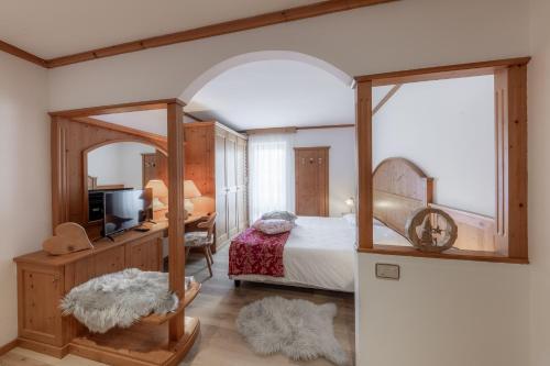 a bedroom with a canopy bed and a mirror at Hotel Primiero in Tonadico