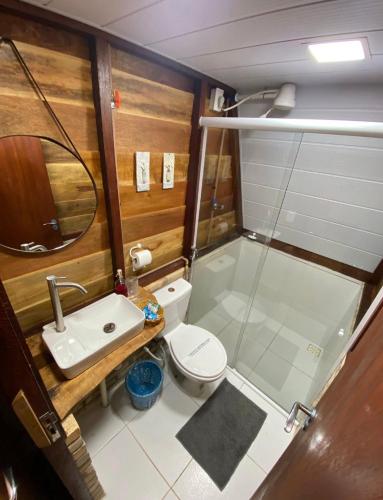 a bathroom with a shower and a toilet and a sink at Pousada Beach House Coqueirinho in Jacumã