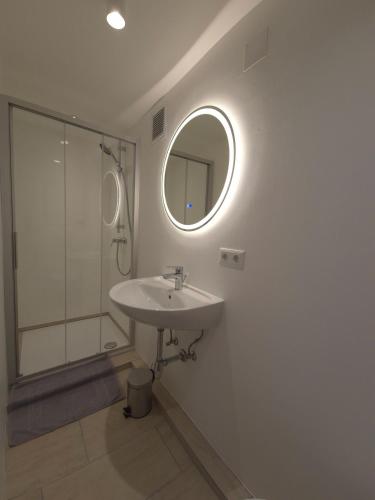 a bathroom with a sink and a shower and a mirror at Ferienwohnung Holiday Lienz in Lienz