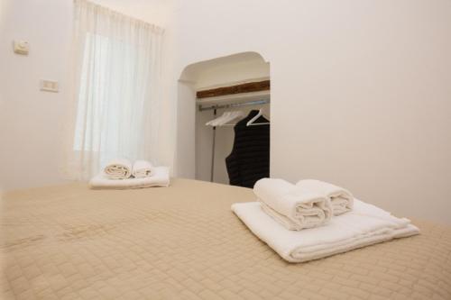 a bedroom with white towels on a bed at Dimora del Murattiano in Monopoli