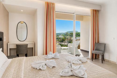 a hotel room with a bed with towels on it at Villa Dimi in Tsilivi