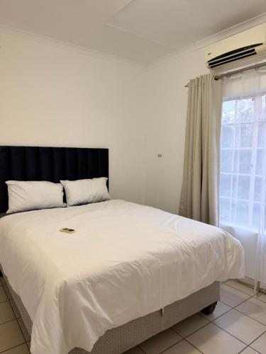 a bedroom with a large white bed with a window at Vellora Haus in Burgersfort