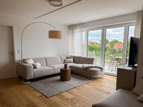 a living room with a couch and a large window at Ferienwohnung Uferchalet am Dümmer See in Lembruch