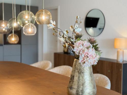 a vase with flowers in it sitting on a table at Ferienwohnung Uferchalet am Dümmer See in Lembruch
