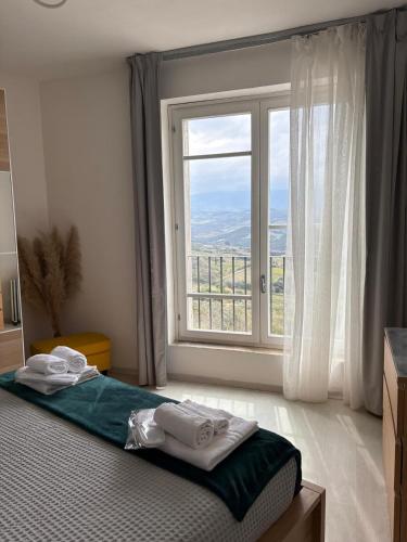 a bedroom with a bed with a large window at Val D'Orcia Panoramic Suite in Montalcino