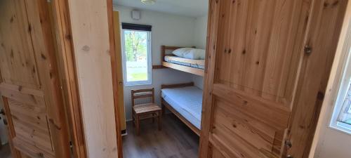 a small room with two bunk beds and a window at Röksvamp 1 in Västra Stensjö