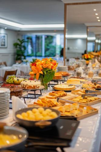a buffet of food on a long table at Biazi Plaza Hotel Bauru in Bauru