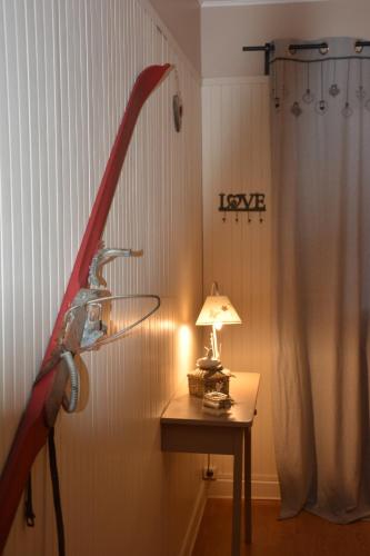 uma lâmpada sobre uma mesa num quarto com uma cortina em Hotel Le Central em La Feclaz