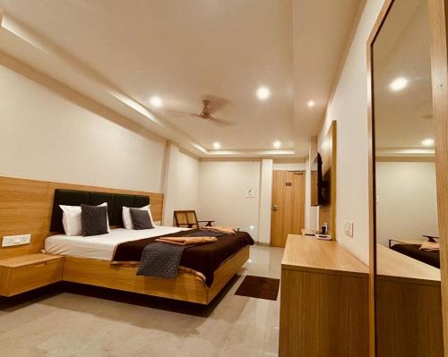 a bedroom with a large bed and a bathroom at Hotel Sree Kanya Inn in Visakhapatnam