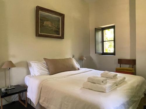a bedroom with a white bed with towels on it at Le Pavillon Du Regisseur in Val-de-Dagne
