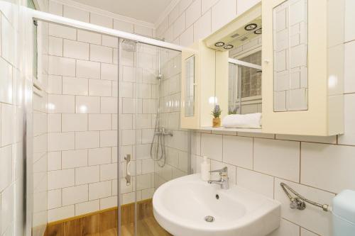 a white bathroom with a sink and a mirror at House Goran in Crikvenica