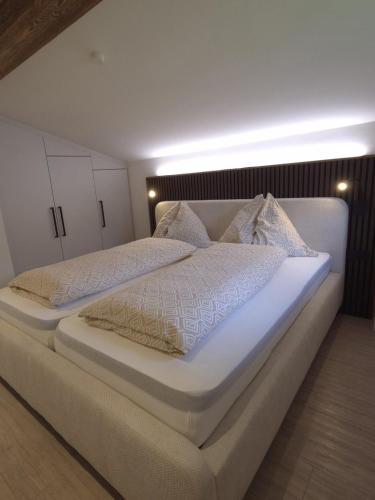 a bedroom with two beds with white sheets and pillows at Ferienwohnung Holiday Lienz in Lienz