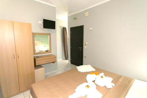 a room with a bed with two white towels at Oliva Resort View & Swimming pool Studios in Parga