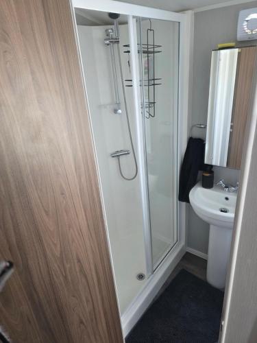 a bathroom with a shower and a sink at 51 Denbigh 8 berth static caravan in Prestatyn