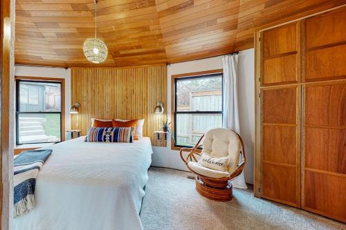 a bedroom with a large bed and a chair at Whidbey Moon Landing in Coupeville
